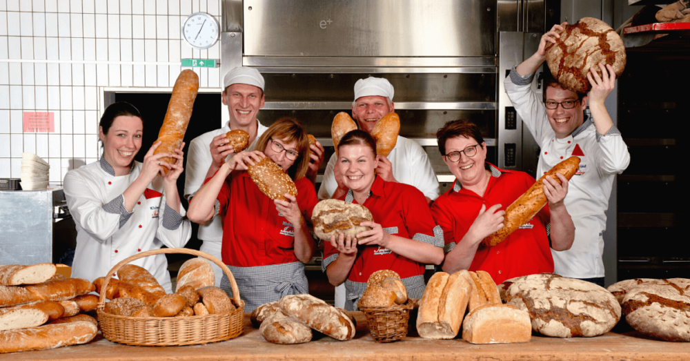 Bäcker und Verkäufer der Bäckerei Imping auf einem Team-Foto in der Backstube