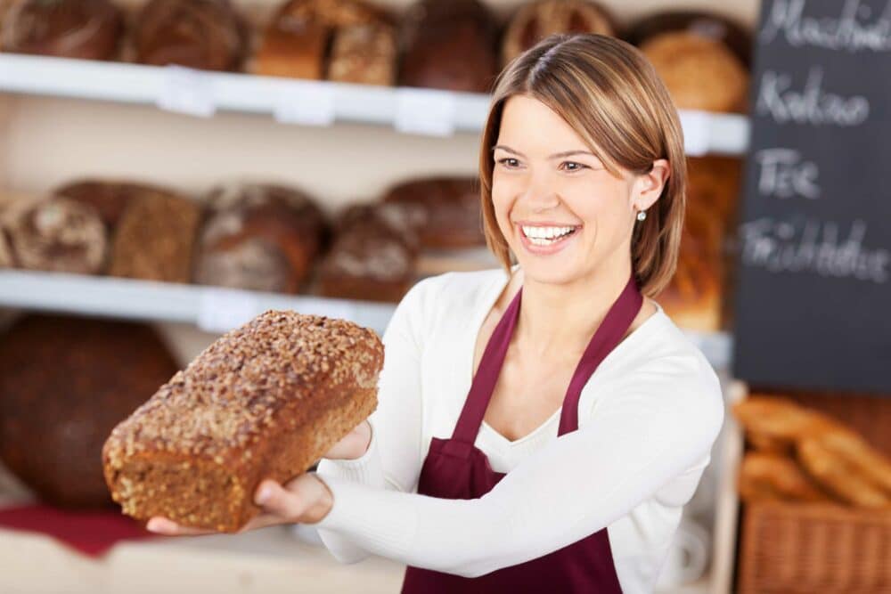 Verkäuferin einer Bäckerei mit Brot in der Filiale