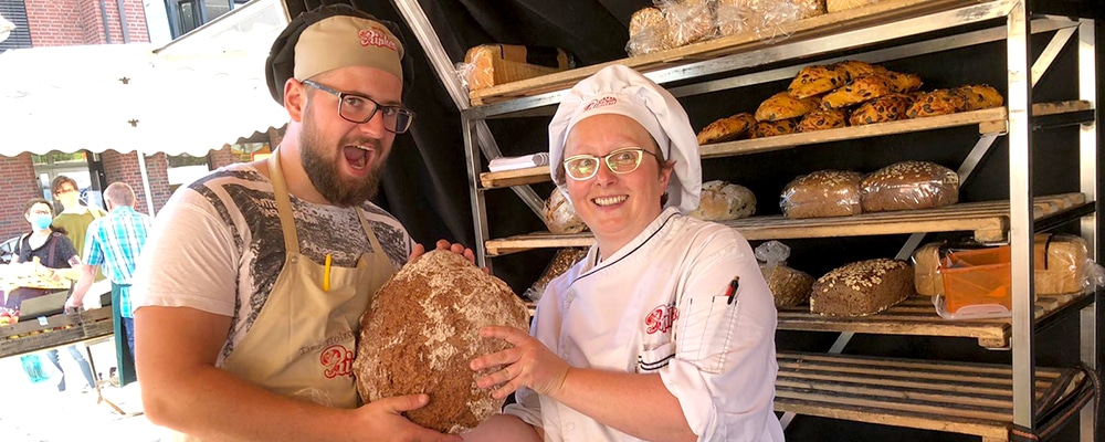 Bäcker und Bäckerin der Holzofenbäckerei Ripken bei der Arbeit auf dem Wochenmarkt