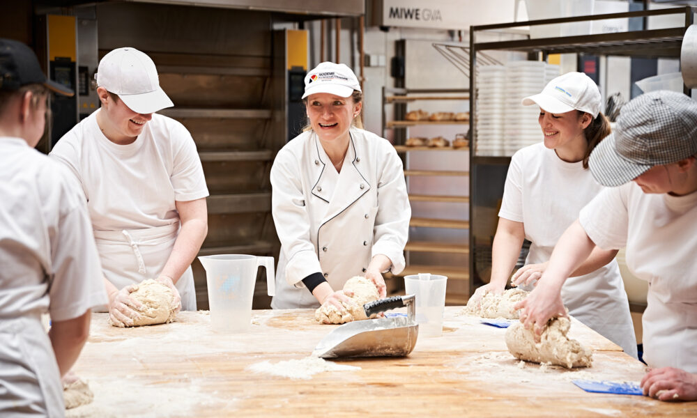 Auszubildende Bäcker und Bäckerin der Bäckerei Ickert bei der Arbeit in der Backstube